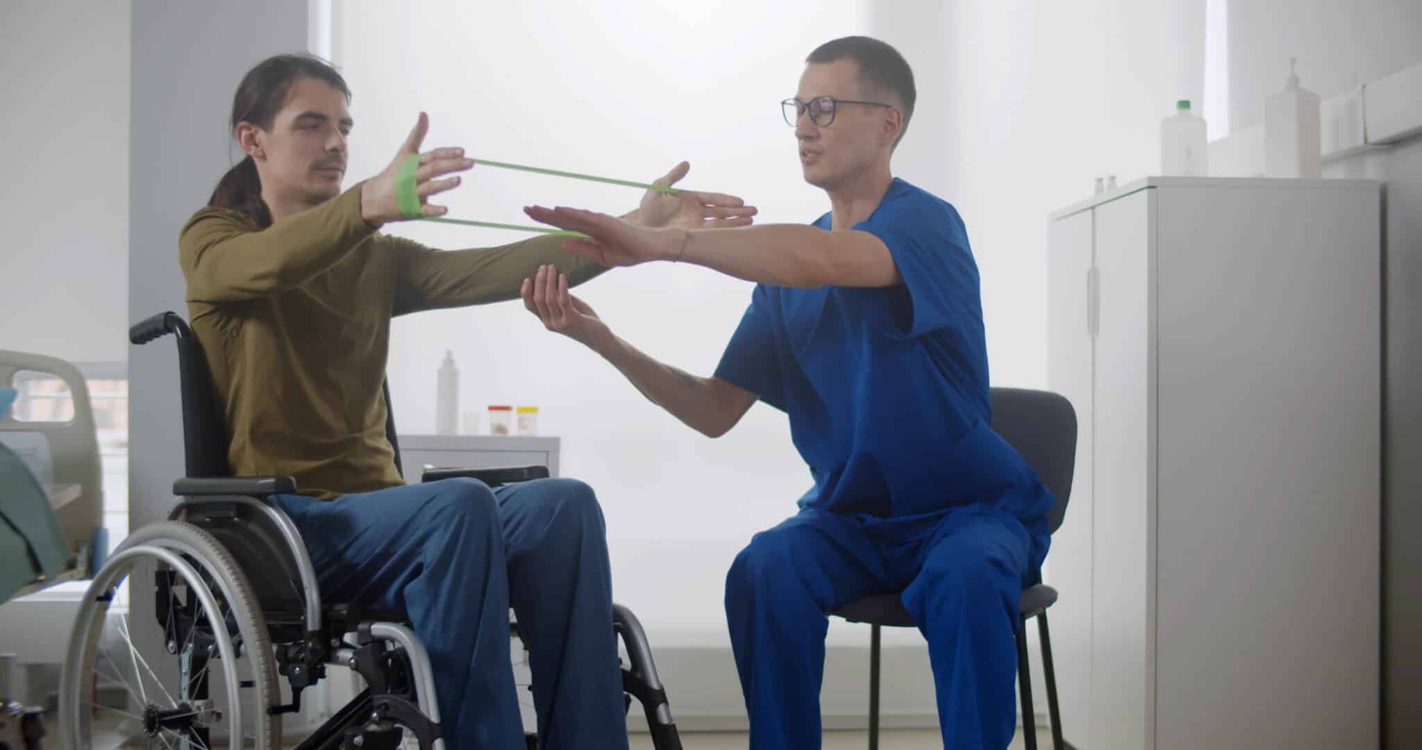 Rehabilitation doctor helping patient in wheelchair to workout with stretch band